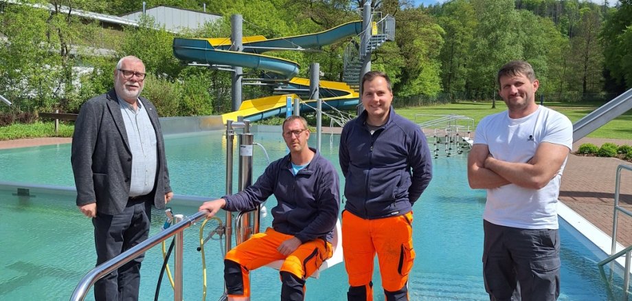 Hier sehen Sie von links nach rechts Stadtbürgermeister Walter Strunk mit den städtischen Mitarbeitern Daniel Sinemus und Philip Comisel sowie von der Verbandsgemeindeverwaltung Dipl. Ing. Sascha Starosta bei der Installation des neuen Poollifts im Freibad.