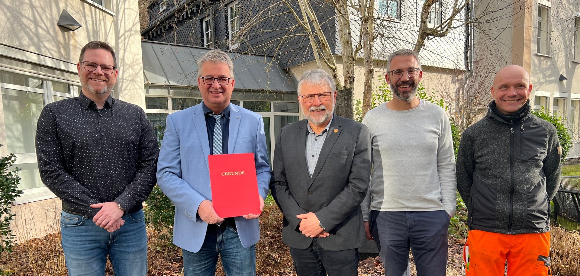 Tobias Friggen (kaufmännischer Werkleiter), Bürgermeister Helmut Stühn, Pascal Weyand (Personalleiter) und Jens Hornickel (Personalratsmitglied und Bauhofvorarbeiter) gratulieren dem Jubilar Ralf Edelmann (technischer Werkleiter), der seine Urkunde in der Hand hält.