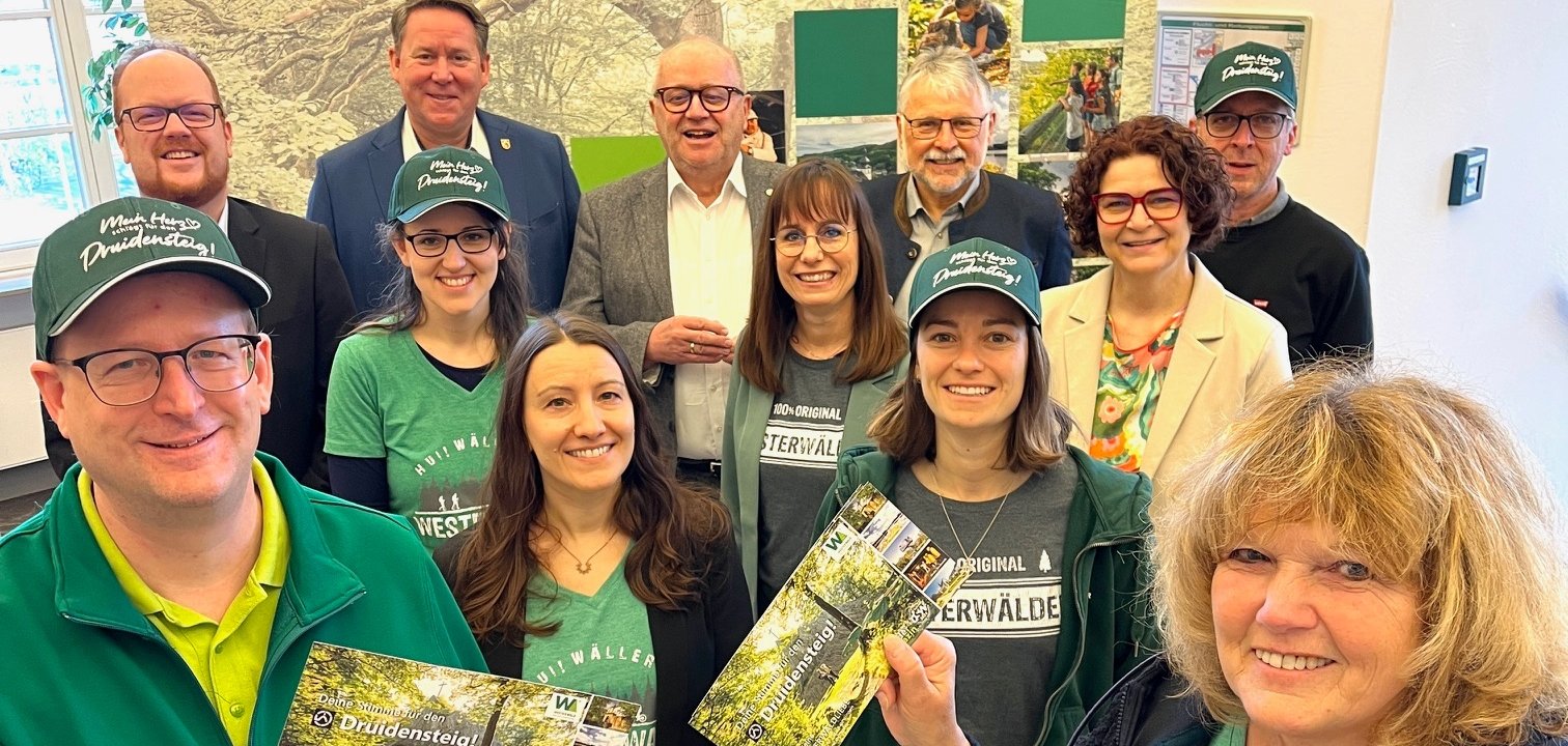 Gruppenbild der Tourismusbeauftragten, die Stimmkarten in der Handhalten und für den Druidensteig werben.