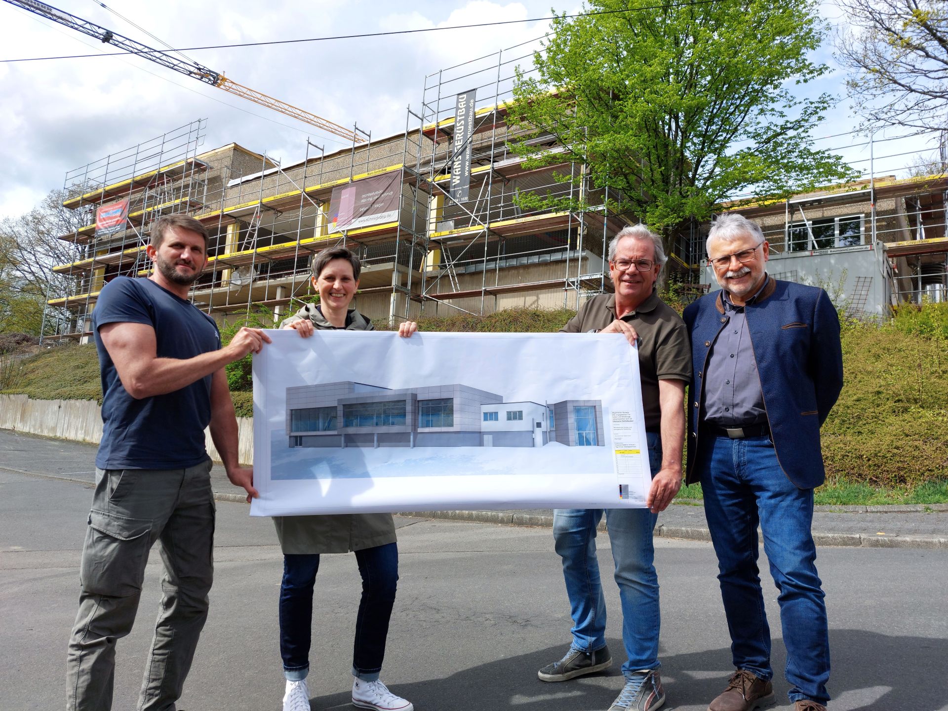 Vor der Baustelle des Hallenbads Daaden wird der Entwurf der neuen Fassade des sanierten Hallenbads präsentiert.