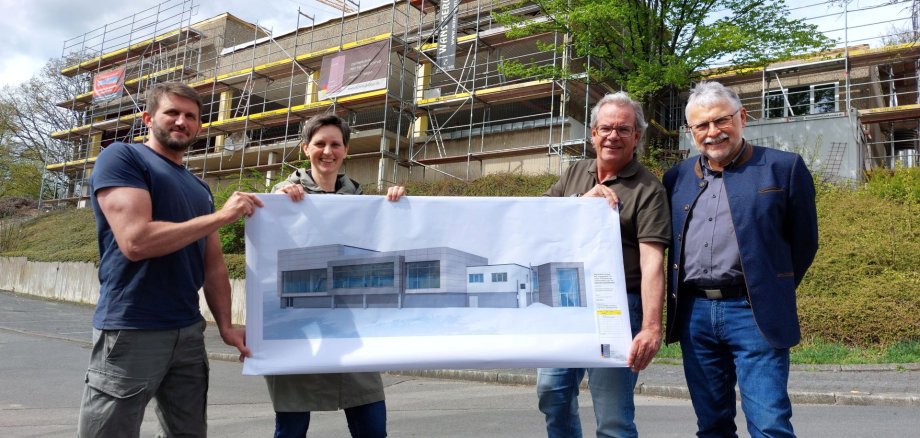 Vor der Baustelle des Hallenbads Daaden wird der Entwurf der neuen Fassade des sanierten Hallenbads präsentiert.