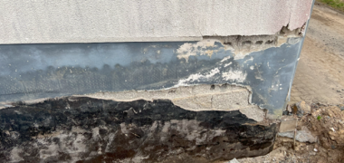 Hier sehen Sie die sanierungsbedürftige Stelle an der Ecke Blindsockel des Bauhofgebäudes in Weitefeld.