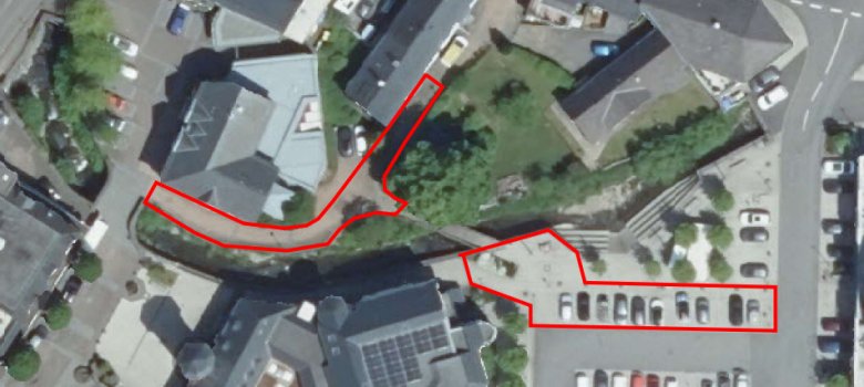 Hier sehen Sie ein Luftbild der Fußgängerbrücke über die Daade am Fontenay-De-Fleury Platz zum Schützenhof. Die rotmarkierten Felder sind Parkplätze und Gehwege, die durch den Brückenneubau gesperrt werden.