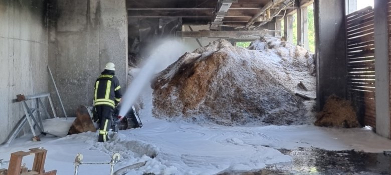 Hier sehen Sie einen Feuerwehrmann beim Löschen im Spänebunker im Industriegebiet Derschen.