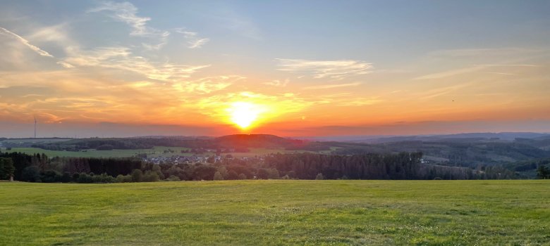 Hier sehen sie einen Fernblick auf Derschen mit Sonnenuntergang