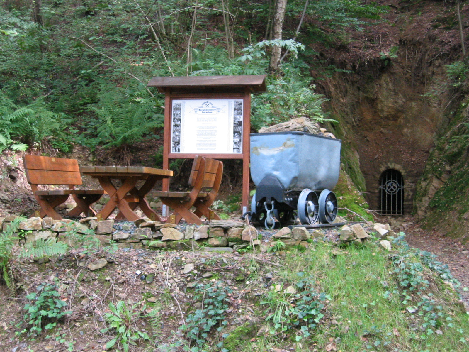 Hier sehen Sie den ehemaligen Stolleneingang mit einer alten Lore