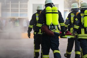 Feuerwehr Hier sehen Sie vier Feuerwehrleute die eine Krankentrage tragen.