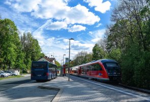 Haltstelle Hier sehen Sie eine Zug und einen Bus die parallel an zwei Haltstellen halten.