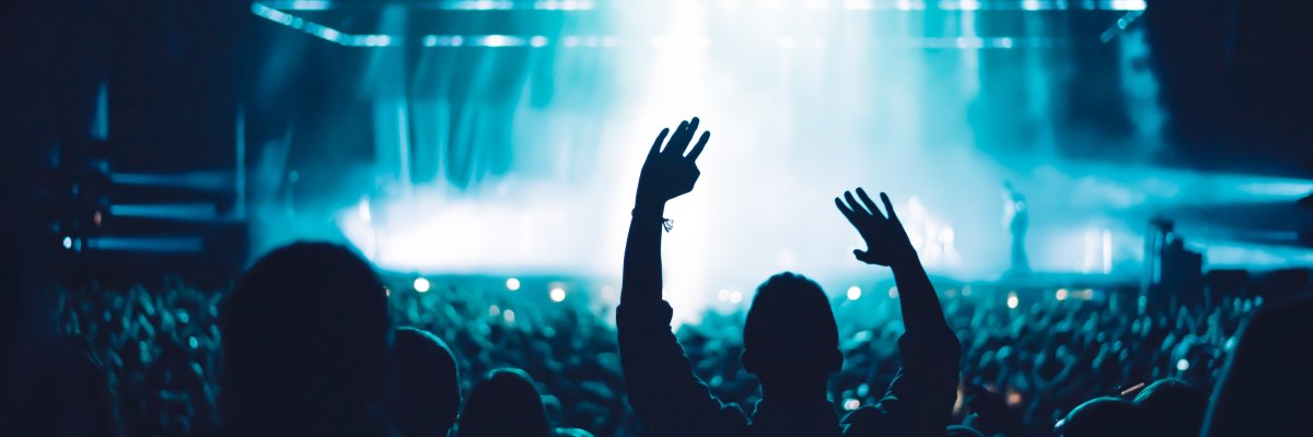 Veranstaltung Hier sehen sie eine feiernde Menschenmenge vor einer Bühne.