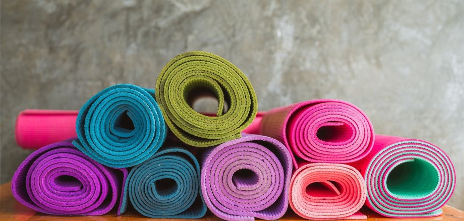 Joga Hier sehen Sie mehrere bunte Jogamatten übereinander gestappelt.
